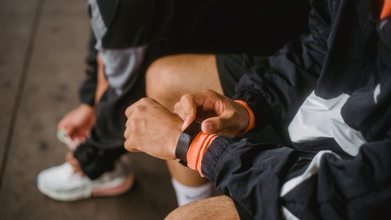 A runner reading a training summary on a watch