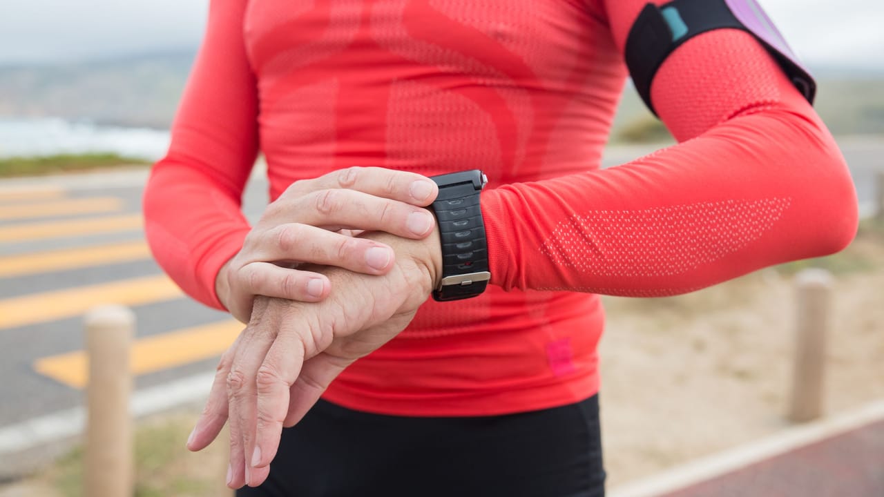 A runner checking heart rate on a GPS watch